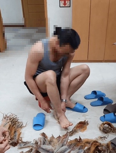 A씨가 맨발로 마른오징어를 펴고 있다. / 사진=A씨 틱톡
