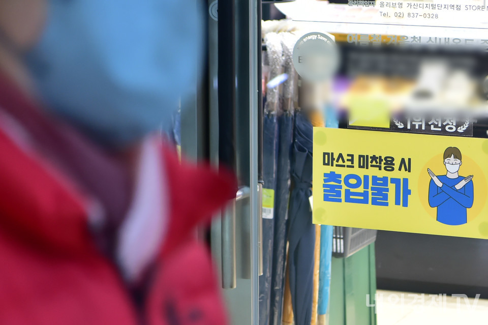 20일 오후 서울 한 시내 상점 입구에 마스크 착용을 알리는 문구가 게시돼 있다.