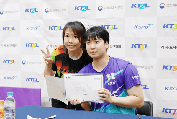 ▲사진: 한 참가자가 한국거래소 곽유빈 선수에게 사인을 받은 뒤 기념 촬영을 하고 있다.
